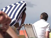 Op het openbare strand worden nudistenvrouwen gefilmd als voyeur