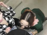 Twee meisjes pijpen een man op een openbare plaats