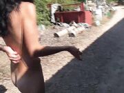 Exhibitionistische nudistenvrouw loopt op de weg dicht bij het strand